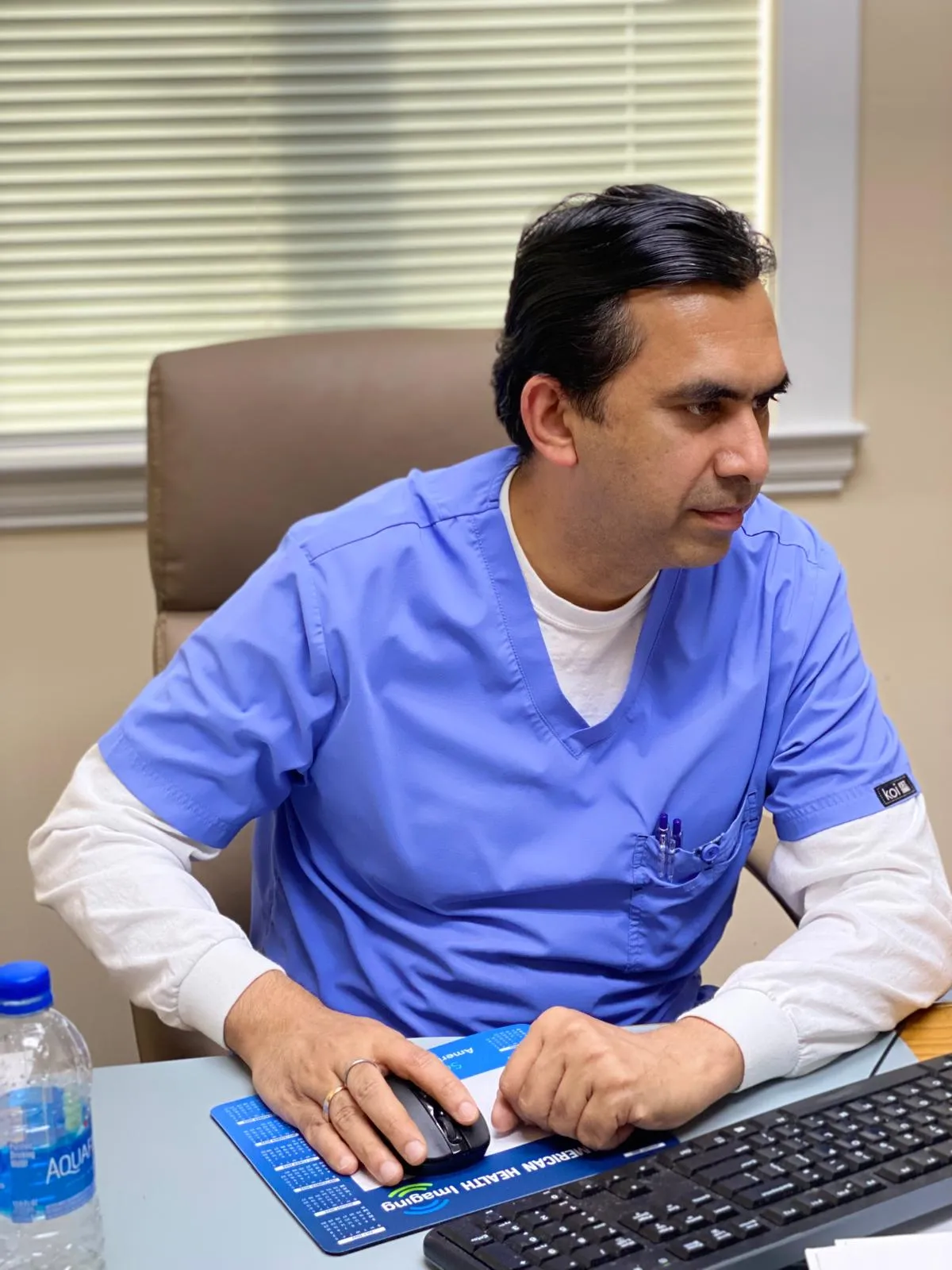 Dr. Kohli reviewing patient care at his desk